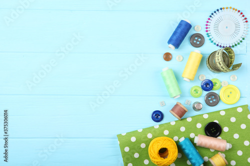 different sewing accessories on the table. Threads, needles, pins, fabric and sewing scissors close up 