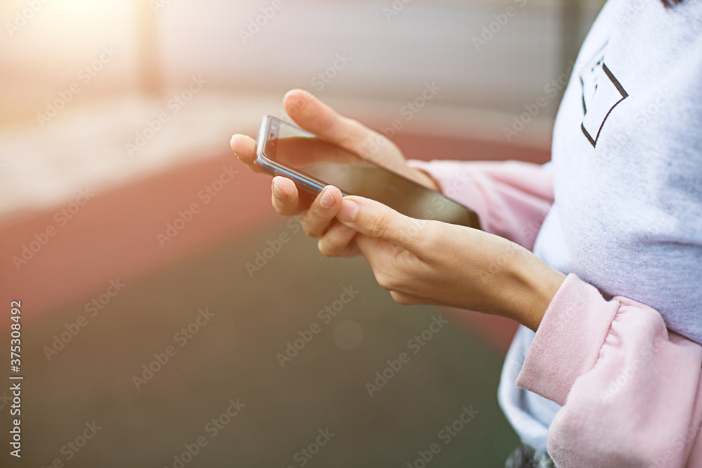 Smartphone in women's hands close-up. Using the phone, fingers on the touch screen of the gadget. Text messages, doing business, Internet applications. Space for text