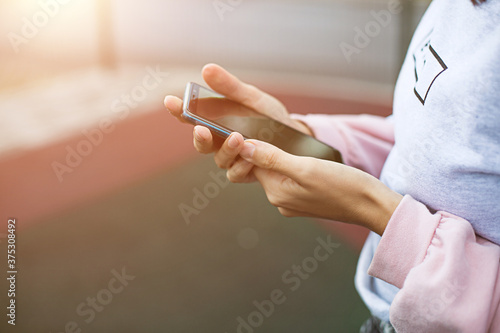 Smartphone in women s hands close-up. Using the phone  fingers on the touch screen of the gadget. Text messages  doing business  Internet applications. Space for text