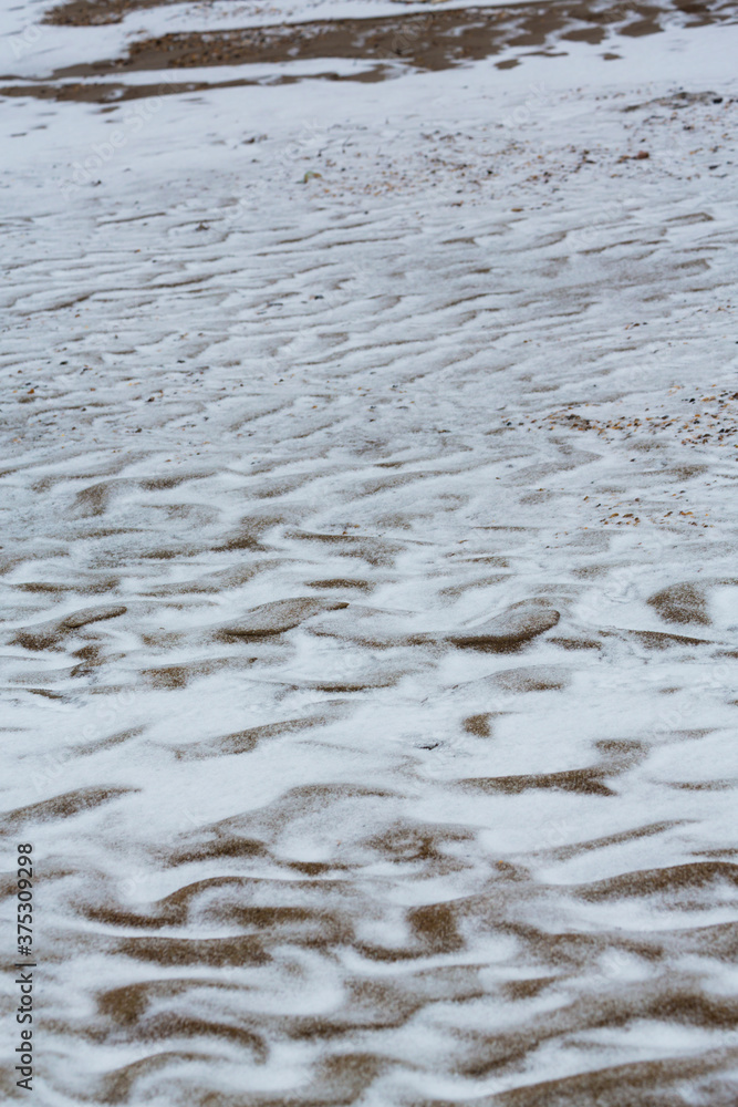 Abstract shapes with sand dunes covered by fresh powder snow, in a wild river bed, in winter Abstract shapes with sand dunes covered by fresh powder snow, in a wild river bed, in winter