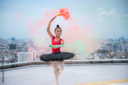 Beautiful young ballet dancer jumping on a color background. © chokniti