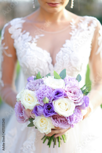 Caucasian bride keeping bouquet of flowers. photo