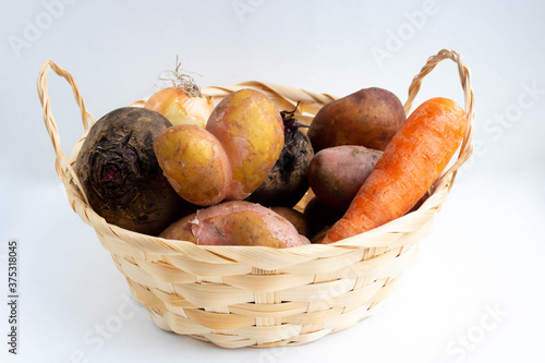 Basket of vegetables, heart potatoes, onions, carrots and beets. The concept of harvest