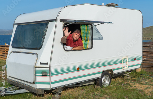 man is relaxing with a travel trailer. caravan trailer of large size