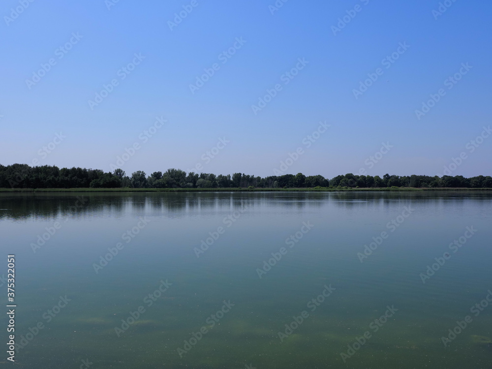 Desolate artificial pond in european Goczalkowice town at Silesian district in Poland, clear blue sky in 2020 warm sunny spring day on June.