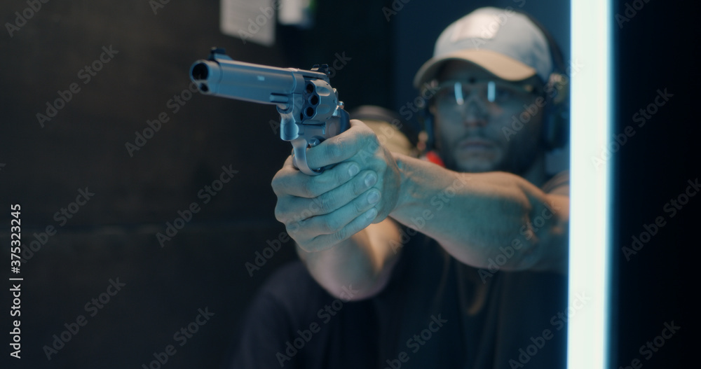Фотография Man learning to fire revolver with trainer