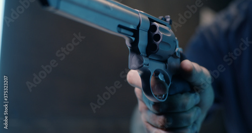 Fototapeta Unrecognizable man reloading revolver in shooting range