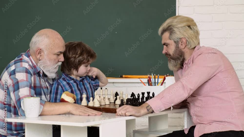 Grandfather Father and grandson playing chess at home. Games and activities for children. Kids early development. Grandfather Father and grandson playing chess at home. Games and activities for children. Kids early development.
