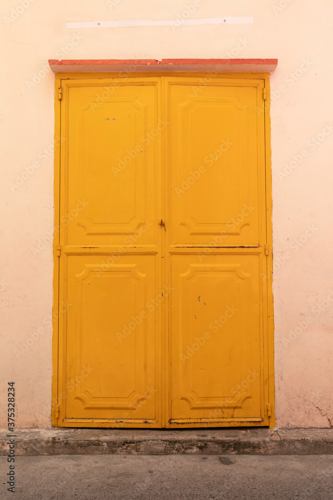 Yellow metal door and wall made of an old Chinese Buddhist Temple in Southest Asia