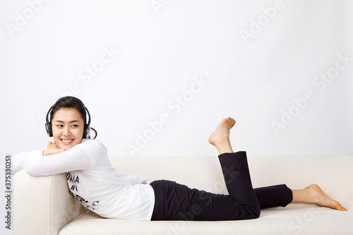 young woman listening to music on sofa