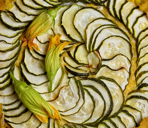 A pattern of spirally arranged zucchini slices and flower
