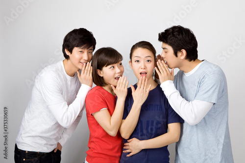 young man whispering to his friends