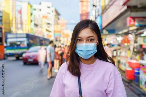 woman wearing mask at Yaowarat road for prevention COVID-19 virus pandemic in Bangkok's Chinatown.