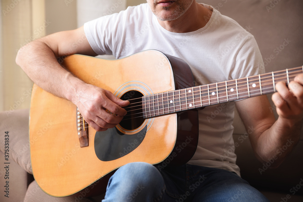 Fototapeta premium Detail of guitar body and man playing man playing