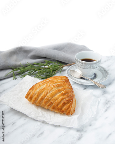 Coffee and puff pastry, rosemary on white marble