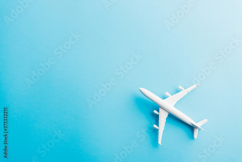 World Tourism Day, Top view flat lay of minimal toy model plane, airplane, studio shot isolated on a blue background, accessory flight holiday concept