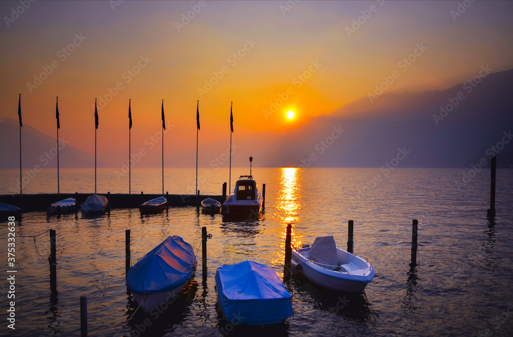 Harbor on a Foggy Alpine Lake Maggiore with Mountain in Sunset in Ascona, Switzerland.