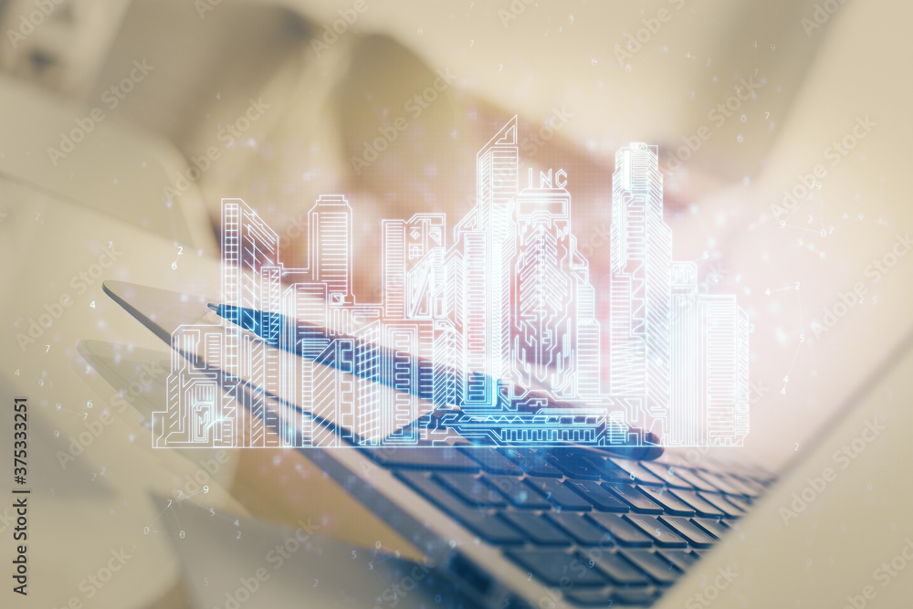 Desktop computer background in office and big town buildings hologram drawing. Double exposure. Smart city concept. Desktop computer background in office and big town buildings hologram drawing. Double exposure. Smart city concept.