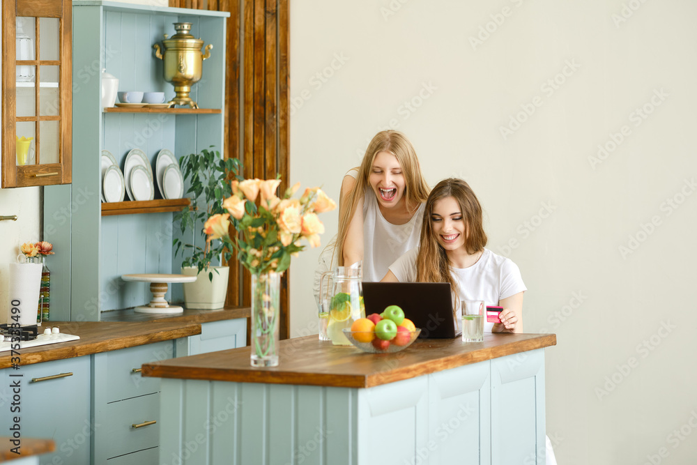 Two young women making online shopping, finding and discussing goods Two young women making online shopping, finding and discussing goods