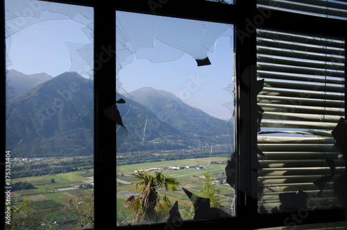 Panoramic View over Mountain from an Abandoned Building Seen Through a Broken Window.