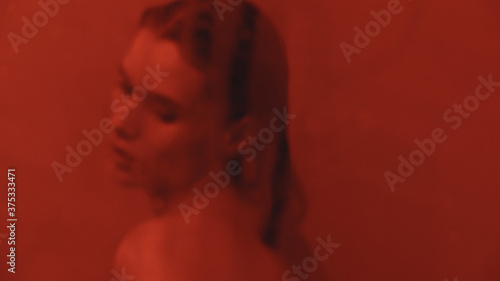 Portrait of sexy girl flirting in bathroom. Wet woman cleaning mirror in bath.