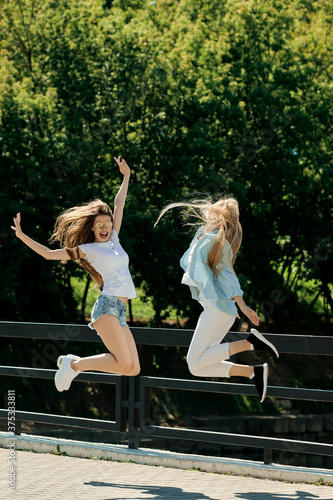 Two positife girls jumping together photo