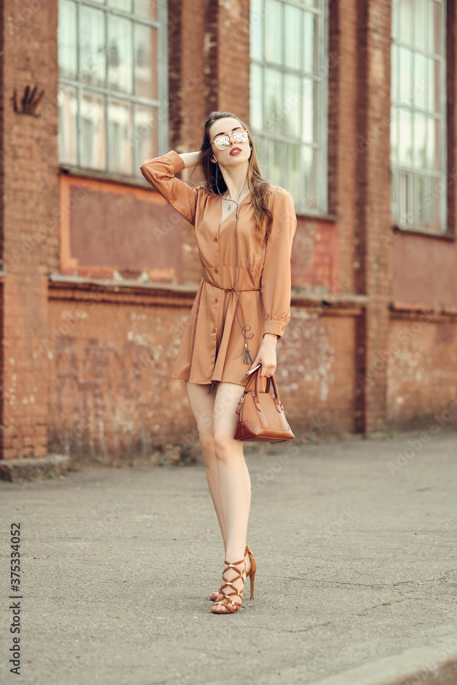 Young woman with earphones walking on the sidewalk Young woman with earphones walking on the sidewalk