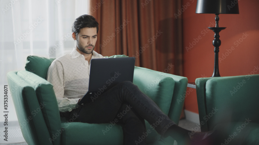 Handsome businessman working laptop at hotel. Business man working computer Handsome businessman working laptop at hotel. Business man working computer