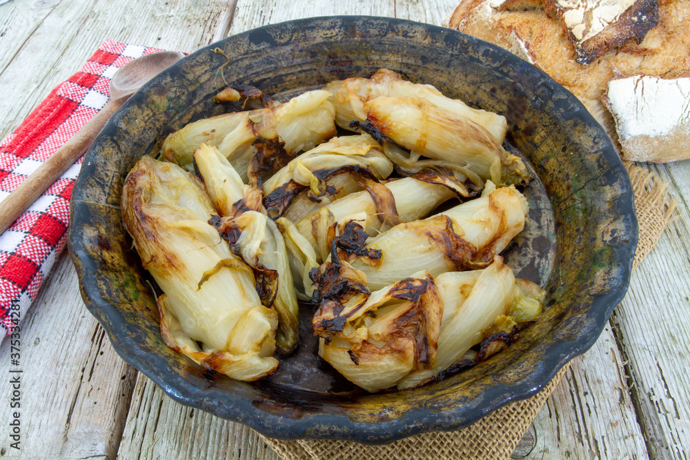 plat d'endives braisées sur une table en bois plat d'endives braisées sur une table en bois
