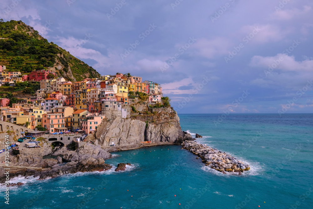 Colorful traditional houses on the rock over Mediterranean sea, Manarola, Cinque Terre, Italy