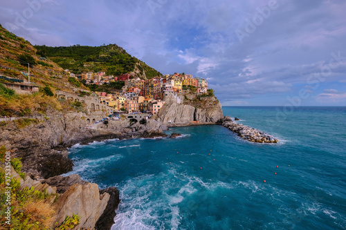 Colorful traditional houses on the rock over Mediterranean sea, Manarola, Cinque Terre, Italy