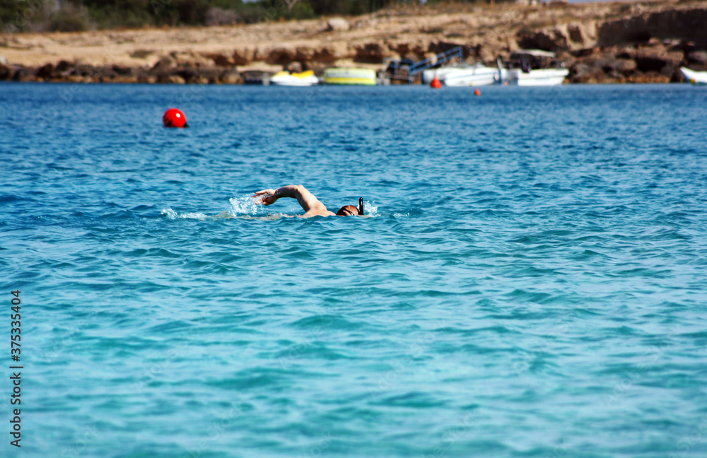 Man is swimming in the mediterranean sea