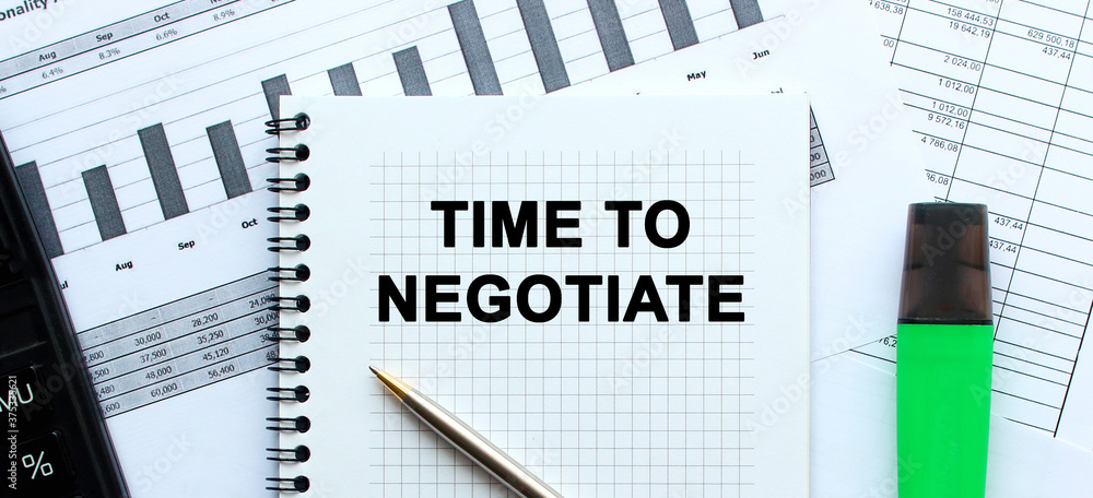 Text TIME TO NEGOTIATE on the page of a notepad lying on financial charts on the office desk. Near the calculator and marker. Business concept. Text TIME TO NEGOTIATE on the page of a notepad lying on financial charts on the office desk. Near the calculator and marker. Business concept.