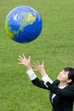 young businesswoman catching a globe