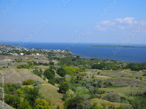 Small village on the river bank. Picturesque summer landscape © Yulia
