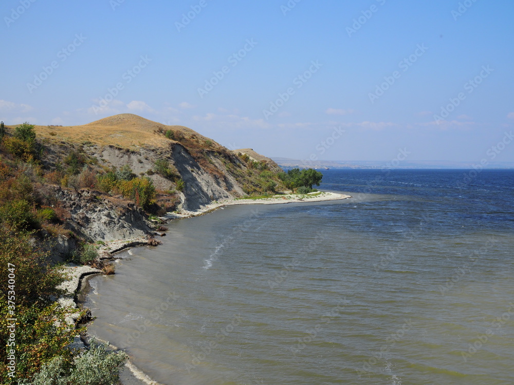 Beautiful river in summer. high Bank above the river. Pine trees grow on a cliff above the river. high cliff above the river