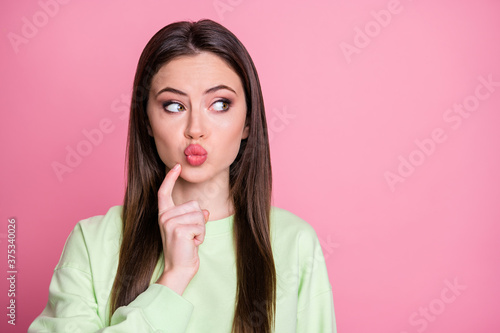 Closeup photo of funny attractive lady straight long hairdo sending air kisses flirty shy look empty space finger on chin wear casual green sweatshirt pullover isolated pink color background