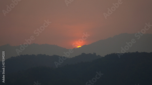 Sunset over a hill with hazy sky near Pha Tang town in Laos.