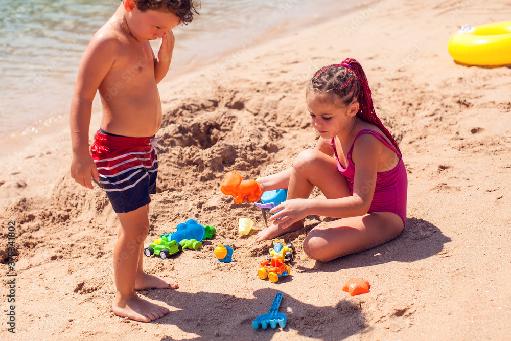 Kids on beach playing with sand. Children, holiday and summer concept Kids on beach playing with sand. Children, holiday and summer concept