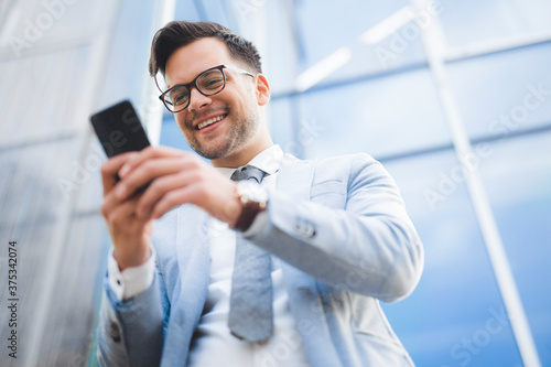 Cheerful businessman using mobile phone