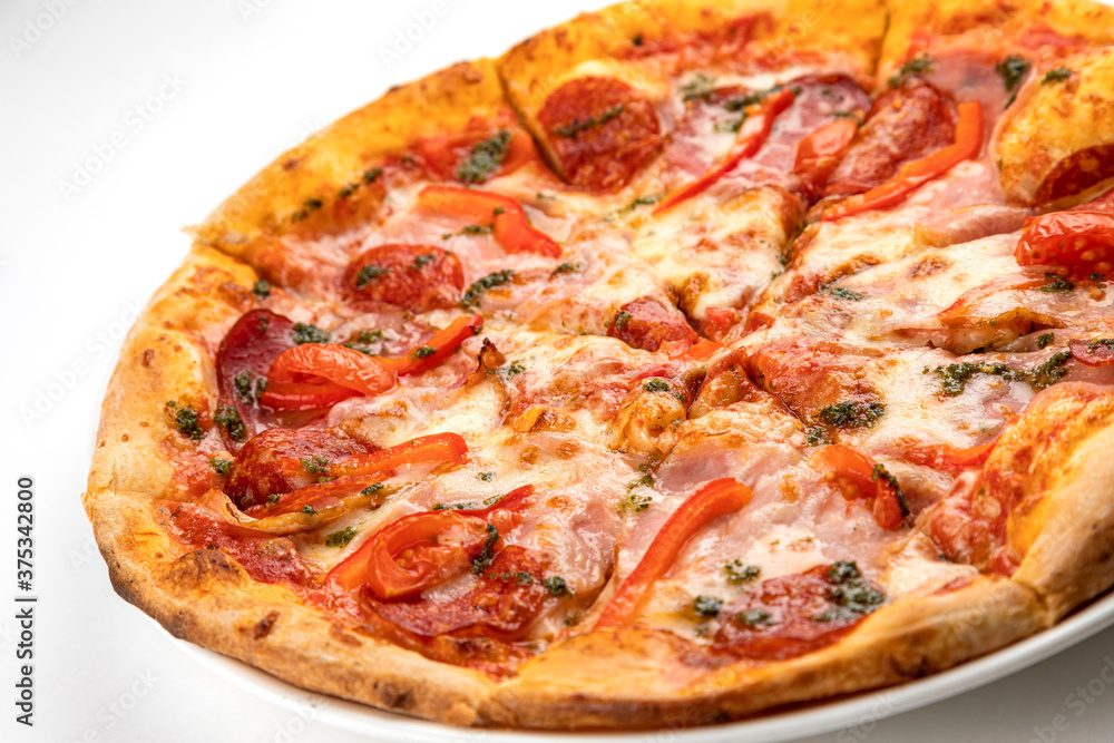 pizza with ham, sausage and tomatoes on a white plate pizza with ham, sausage and tomatoes on a white plate