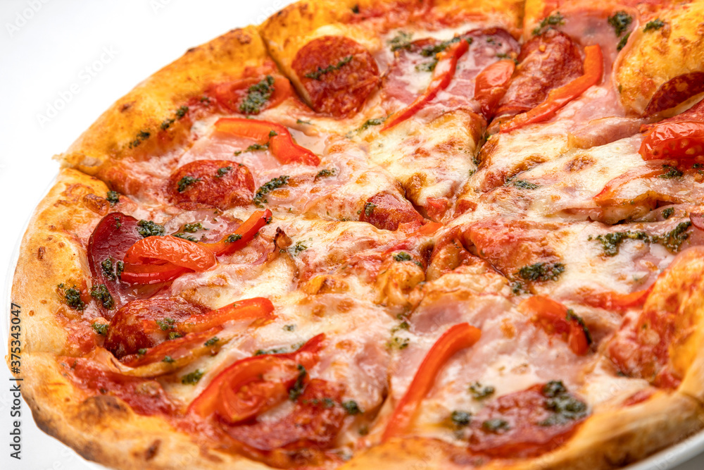 pizza with ham, sausage and tomatoes on a white plate pizza with ham, sausage and tomatoes on a white plate