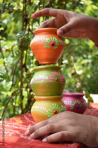 hand holding handmade decorated colored pottery