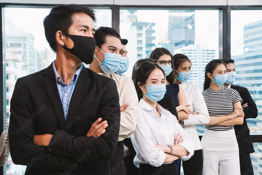 Business people wearing face mask standing and crossed arms in office. New normal office. Business people wearing face mask standing and crossed arms in office. New normal office.