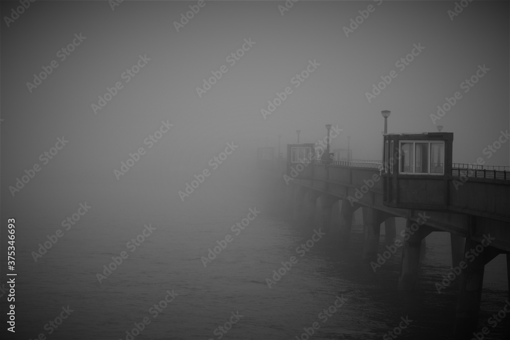Pier in fog, black and white