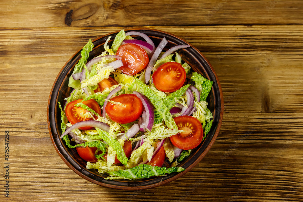 Healthy salad with savoy cabbage, cherry tomato, red onion and olive oil on wooden table. Top view Healthy salad with savoy cabbage, cherry tomato, red onion and olive oil on wooden table. Top view