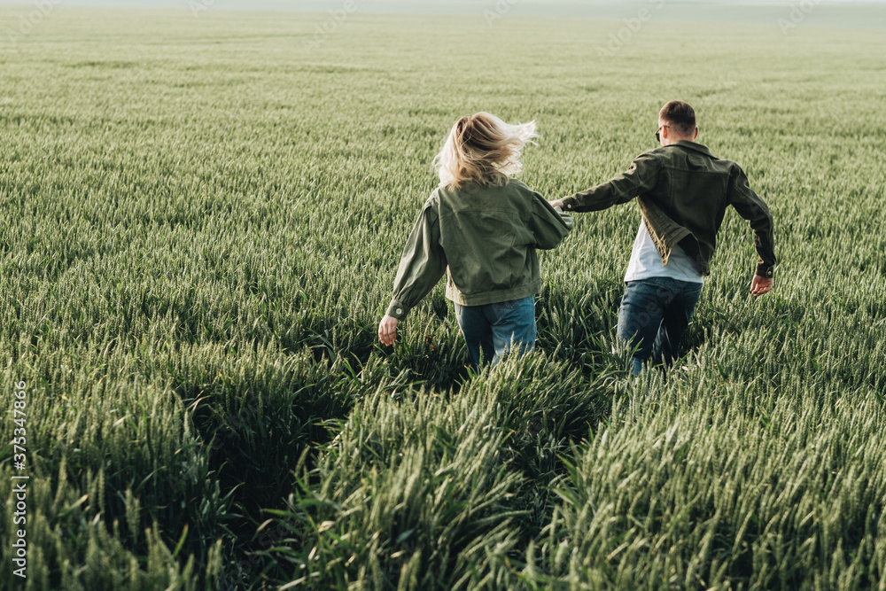 Man and Woman Dressed Alike in Olive Jacket Having a Good Time Outside the City