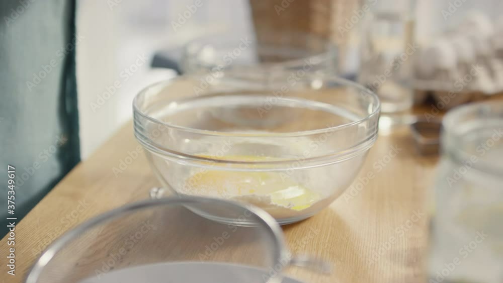 Handheld close up shot of hands of unrecognizable elderly man cracking egg into bowl with flour Handheld close up shot of hands of unrecognizable elderly man cracking egg into bowl with flour