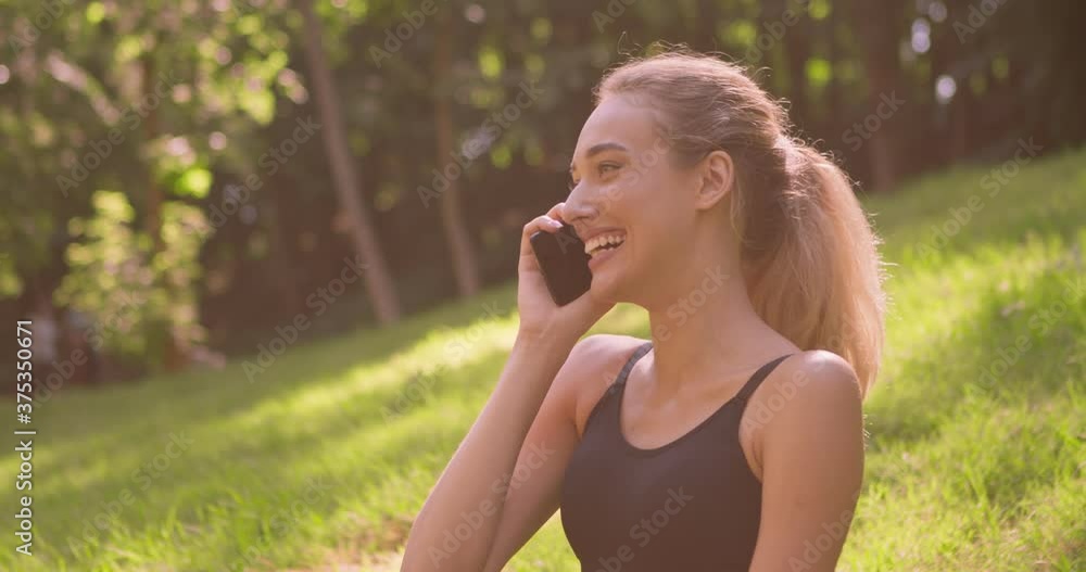 Outdoor portrait of happy young woman talking with boyfriend on cellphone and laughing Outdoor portrait of happy young woman talking with boyfriend on cellphone and laughing