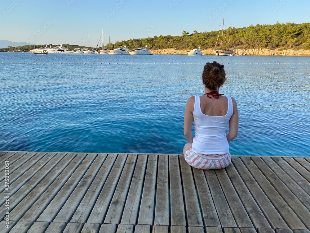 woman sitting wooden floor on the sea